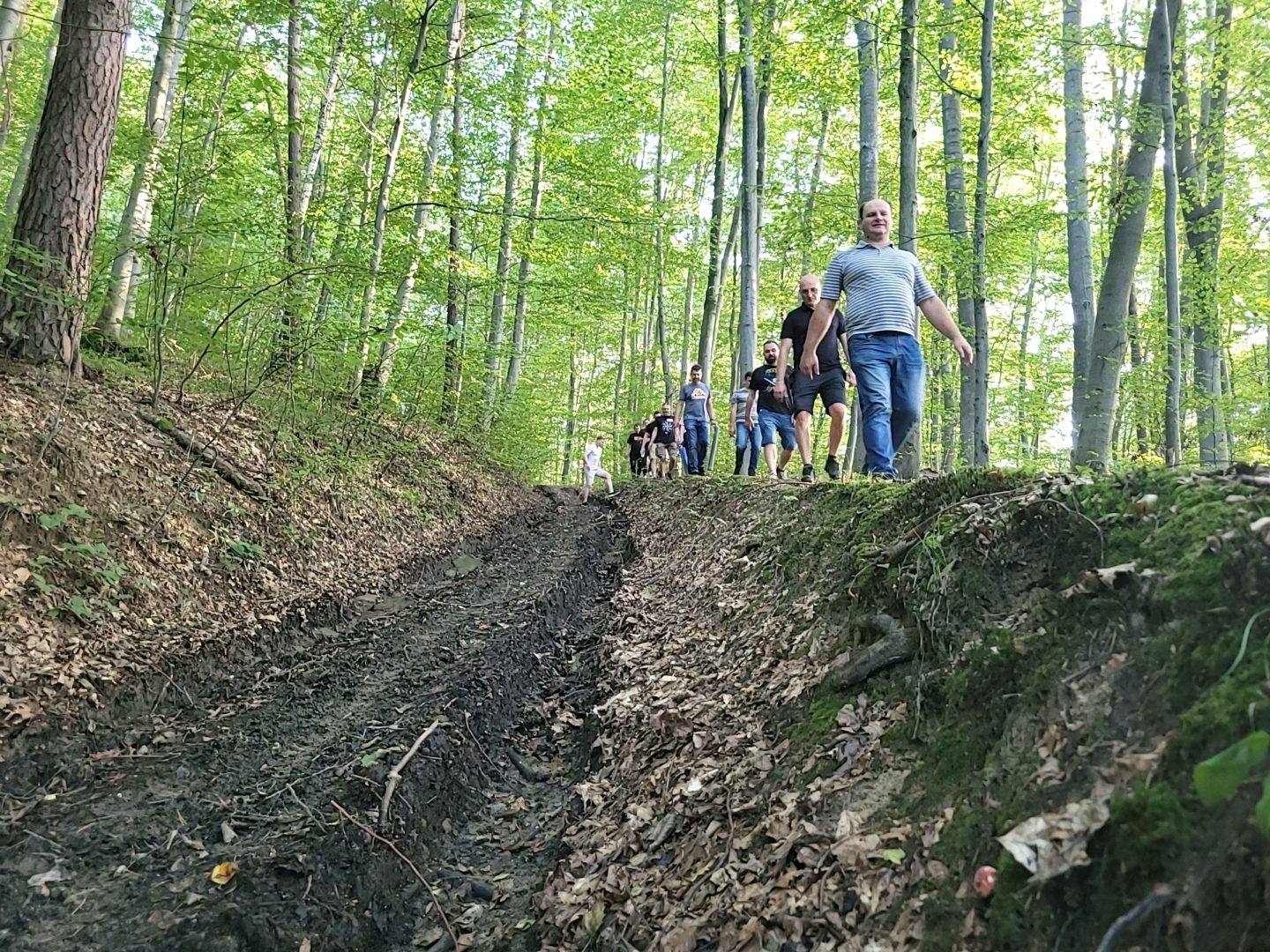 Uczestnicy idą leśną ścieżką do kolejnego punktu